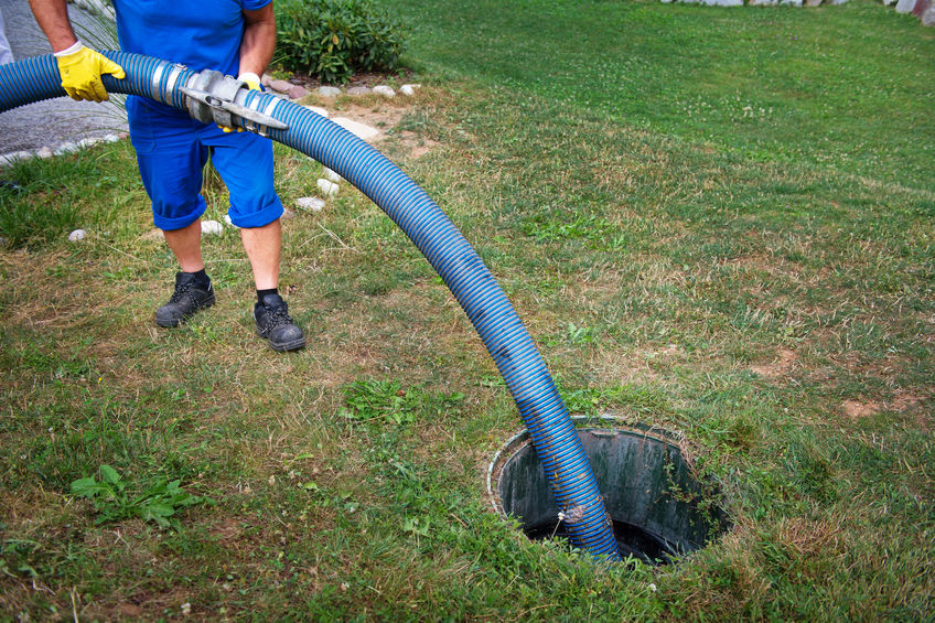Image of man pumping a septic tank to convey septic pumping cost when septic tank is ful - wilson services
